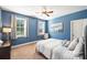 Comfortable bedroom with a blue accent wall, carpet flooring, and two windows offering natural light at 4941 Campobello Dr, Monroe, NC 28110