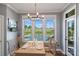 Dining area showcasing a view of the backyard pool, complemented by a wooden dining table and designer lighting at 4941 Campobello Dr, Monroe, NC 28110