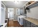 Functional laundry room with gray cabinets, granite countertops, and modern washer and dryer at 4941 Campobello Dr, Monroe, NC 28110