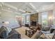 Bright living room featuring a stone fireplace, coffered ceiling, and open access to the entry hallway and staircase at 4941 Campobello Dr, Monroe, NC 28110