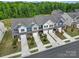 Aerial view of new townhomes with attached garages and landscaping, surrounded by lush greenery at 5034 Moss Pine Way, Tega Cay, SC 29708