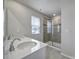 Bright bathroom featuring double sink vanity with neutral tile flooring and glass enclosed shower at 5034 Moss Pine Way, Tega Cay, SC 29708