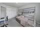 Bedroom with bunk beds, gray carpet, a desk, and double door closet at 5034 Moss Pine Way, Tega Cay, SC 29708