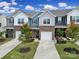 Exterior front view of townhomes showcasing brick facades, attached garages, and landscaping at 5034 Moss Pine Way, Tega Cay, SC 29708