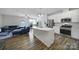 Open-concept kitchen with an island, stainless steel appliances, and seamless flow to living area at 5034 Moss Pine Way, Tega Cay, SC 29708