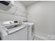 Laundry room with front load washer and dryer and wire shelf at 5034 Moss Pine Way, Tega Cay, SC 29708