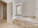 Bright bathroom featuring a soaking tub with tiled surround and a separate shower at 5108 Tedorill Ln, Charlotte, NC 28226