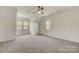 Carpeted bedroom featuring multiple windows for natural light and a ceiling fan for comfort at 5108 Tedorill Ln, Charlotte, NC 28226