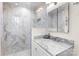 Modern bathroom featuring a marble vanity, glass shower, and tiled walls at 5162 Lincrest Pl, Charlotte, NC 28211