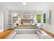 Sunlit bedroom featuring hardwood floors, plantation shutters, and neutral decor at 5162 Lincrest Pl, Charlotte, NC 28211