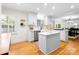 Lovely kitchen features bright white cabinetry, countertops and backsplash with stainless steel appliances and hardwood floors at 5162 Lincrest Pl, Charlotte, NC 28211