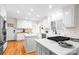 A beautiful kitchen featuring white cabinetry, countertops and backsplash, a gas range, and hardwood floors at 5162 Lincrest Pl, Charlotte, NC 28211