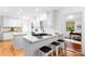 Bright kitchen boasts a gas range on the island with white cabinets, countertops and backsplash, plus stainless steel appliances at 5162 Lincrest Pl, Charlotte, NC 28211