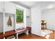 Mudroom area with built-in bench, storage cabinets, coat hooks, and view to the office area at 5162 Lincrest Pl, Charlotte, NC 28211