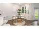 Bright dining area features a glass table, modern white chairs, and ample natural light from the window at 6011 Chelsea Oaks Rdg, Tega Cay, SC 29708