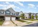 Street view showing well-kept townhomes, with single car garages and vibrant green lawns at 6011 Chelsea Oaks Rdg, Tega Cay, SC 29708