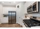 Modern kitchen with stainless steel appliances, white cabinetry, and an adjacent stove and microwave at 6011 Chelsea Oaks Rdg, Tega Cay, SC 29708