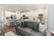 Open-concept living space with modern furniture, a gray sofa, and a view of the kitchen with white cabinetry at 6011 Chelsea Oaks Rdg, Tega Cay, SC 29708