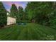 Expansive backyard featuring a fire pit with Adirondack seating and mature trees at 611 Meadow Lake Dr, Matthews, NC 28105