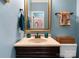 Powder room features a pedestal sink, decorative mirror, and blue walls at 611 Meadow Lake Dr, Matthews, NC 28105
