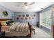 Relaxing bedroom features a wooden bed, eclectic hats on the wall, and a bright window at 611 Meadow Lake Dr, Matthews, NC 28105
