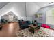 Bonus room features a blue sofa, wood floors, and eclectic decorations at 611 Meadow Lake Dr, Matthews, NC 28105