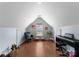 Bright bonus room features hardwood floors and is decorated with a piano, chair, and plant at 611 Meadow Lake Dr, Matthews, NC 28105
