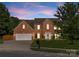 Inviting brick home with well-manicured front lawn and an attached two-car garage at 611 Meadow Lake Dr, Matthews, NC 28105