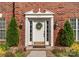 Close up of a white front door with sidelights, a wreath, and manicured landscaping at 611 Meadow Lake Dr, Matthews, NC 28105