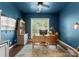 Serene home office with dark blue walls, natural light, and wooden desk at 611 Meadow Lake Dr, Matthews, NC 28105