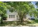 A verdant backyard features a concrete patio, a well-maintained lawn, and several shade trees at 8221 Brookings Dr, Charlotte, NC 28269