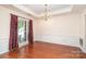 Formal dining area featuring hardwood floors, wainscoting, and a stylish chandelier at 8221 Brookings Dr, Charlotte, NC 28269