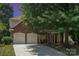 Traditional brick home with an attached two-car garage, a manicured lawn, and mature landscaping at 8221 Brookings Dr, Charlotte, NC 28269