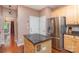 Granite-topped kitchen island complements stainless steel fridge and nearby access to doors and other rooms at 8221 Brookings Dr, Charlotte, NC 28269