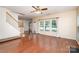 Open-concept living room boasts hardwood floors, large windows, and access to stairs and other rooms at 8221 Brookings Dr, Charlotte, NC 28269