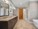 Bright bathroom featuring double vanity with granite countertops, a sliding barn door, and a soaking tub at 8825 Harris Rd, Concord, NC 28027