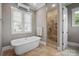 Bathroom featuring soaking tub, tiled shower, and double windows with bright natural light at 8825 Harris Rd, Concord, NC 28027