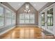 Bright dining room with large windows, chandelier lighting, hardwood floors, and access to the screened-in porch at 8825 Harris Rd, Concord, NC 28027