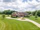 Beautiful home featuring manicured lawn, circular drive, mature trees, and attached garage at 8825 Harris Rd, Concord, NC 28027