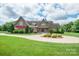 Beautiful home featuring manicured lawn, circular drive, mature trees, and attached garage at 8825 Harris Rd, Concord, NC 28027