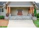 Inviting front porch with stone accents, wooden columns, and double-door entrance at 8825 Harris Rd, Concord, NC 28027
