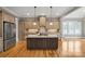 Bright kitchen featuring stainless steel appliances, a large island with granite countertops, and hardwood floors at 8825 Harris Rd, Concord, NC 28027