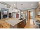 Open kitchen layout with stainless steel appliances, hardwood floors, and a granite countertop island at 8825 Harris Rd, Concord, NC 28027