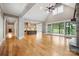 Open living room features wood floors, high ceilings, stone fireplace and access to kitchen and screened in porch at 8825 Harris Rd, Concord, NC 28027