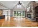 Spacious living room boasts a stone fireplace, wood floors, and sliding glass doors to the outdoor living space at 8825 Harris Rd, Concord, NC 28027