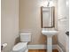 Traditional powder room with a pedestal sink, toilet, and wood flooring at 8825 Harris Rd, Concord, NC 28027