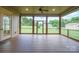 Covered screened porch, featuring wood floors and exterior view of backyard at 8825 Harris Rd, Concord, NC 28027