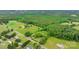 Expansive aerial view showcases a vast property with lush greenery and a mix of open fields and wooded areas at 9161 Paul Payne Store Rd, Stony Point, NC 28678