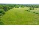 An aerial perspective of a grassy field, trees, and a house, showcasing the property's size and location at 9161 Paul Payne Store Rd, Stony Point, NC 28678