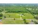 Scenic aerial shot of a sprawling property featuring a mix of verdant meadows, mature trees, and scattered residential houses at 9161 Paul Payne Store Rd, Stony Point, NC 28678